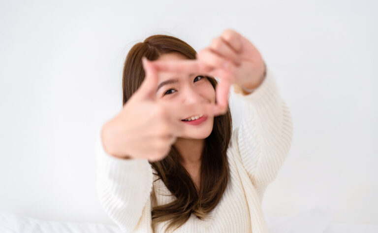 Young asian woman happy and making frame with fingers