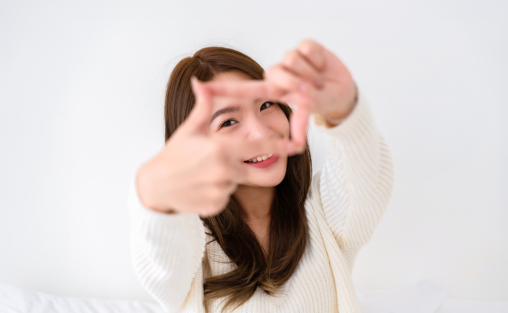 Young asian woman happy and making frame with fingers