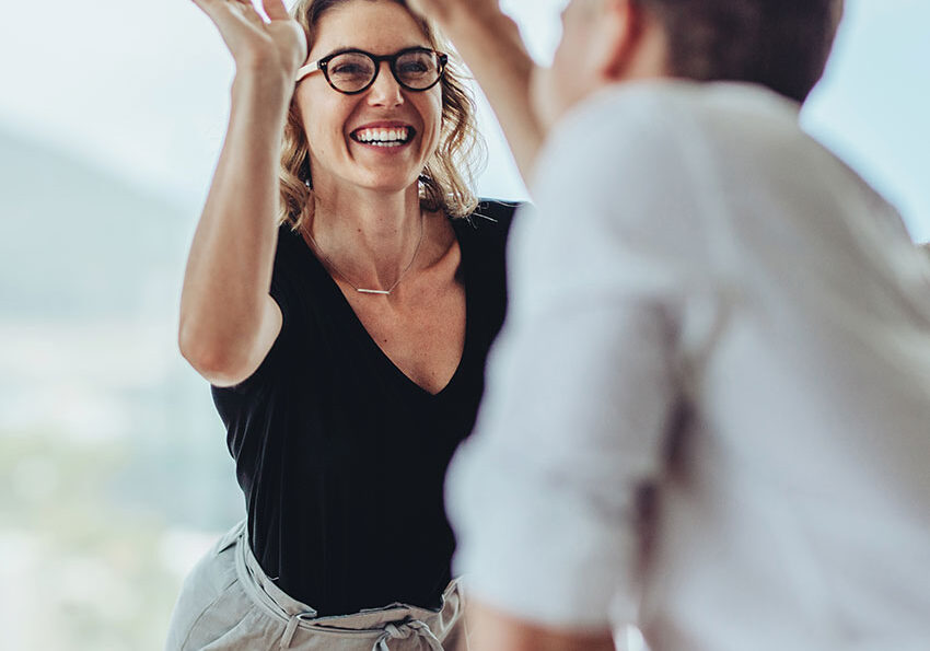 Businesswoman-giving-a-high-five-to-a-colleague-in-meeting
