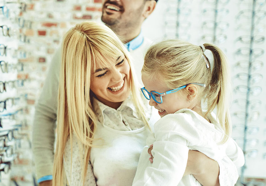 Happy-family-choosing-glasses-in-optics-store.-2