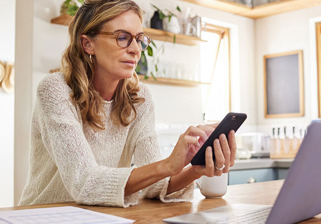 Woman,-laptop-or-fintech-phone-app-in-house-or-home-kitchen-for-finance-budget
