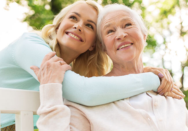 family,-generation-and-people-concept---happy-smiling-young-daughter-with-senior-mother-sitting-on-park-bench-and-hugging