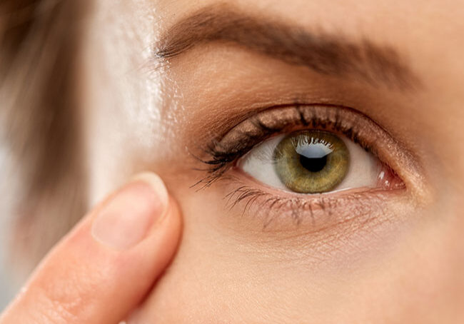 vision,-beauty-and-people-concept---close-up-of-woman-pointin-finger-to-eye